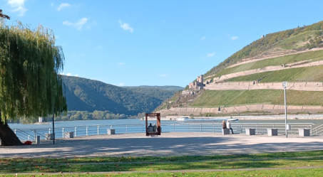 Foto: der Fluß Nahe mündet von links kommend in den Rhein, dahinter ist die Schlucht des Mittelrheintals zu sehen